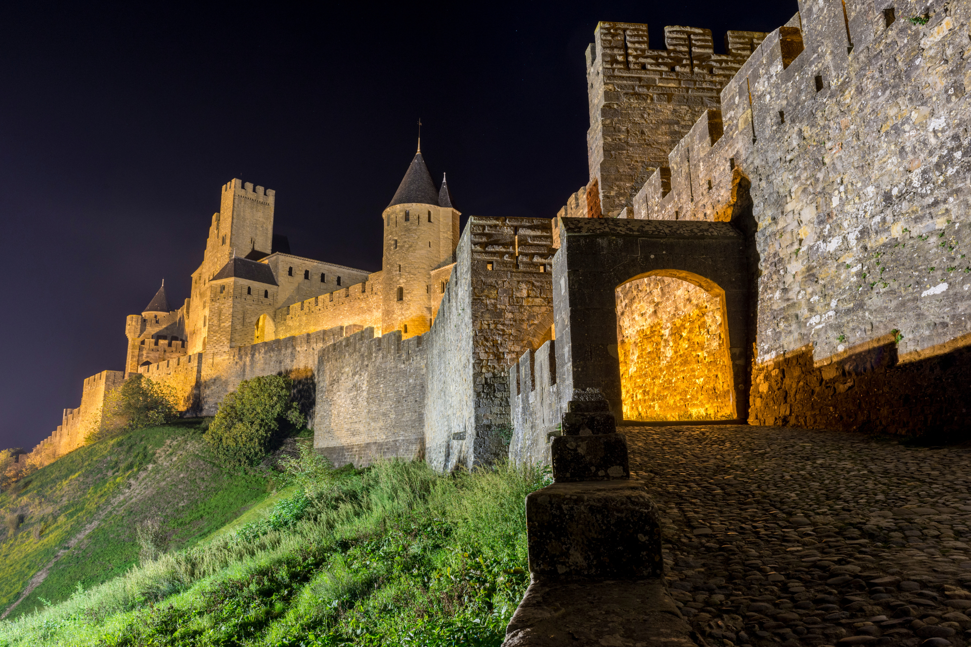 Stroll Walk by night in the medieval cite of Carcassonne Citadel in Occitanie France Aude South of France lights lices Exterior Ramparts Castle